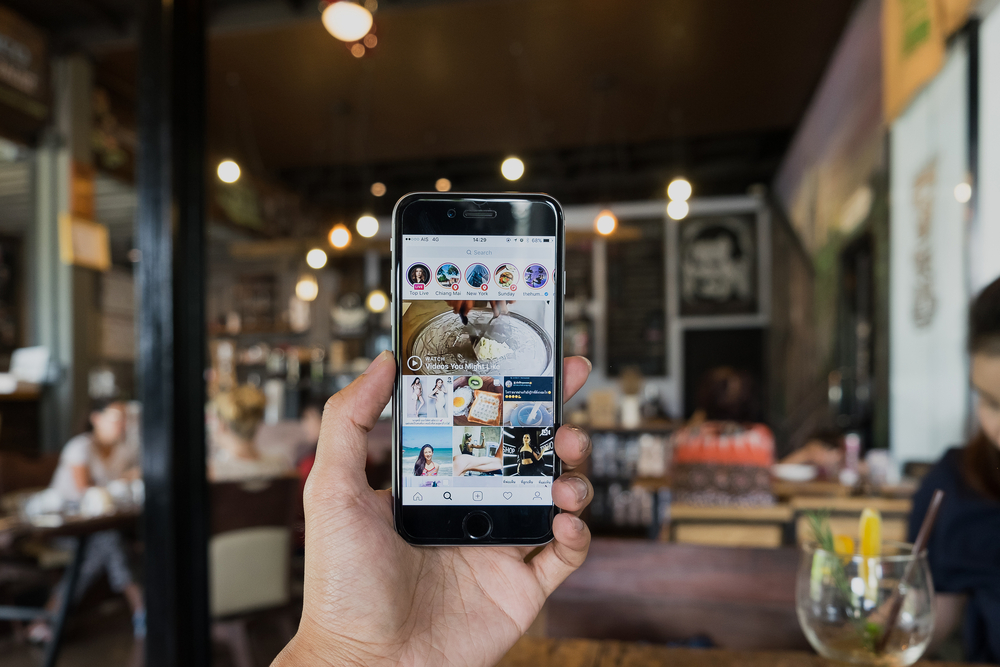 A man hand holding iphone with search page screen of instagram application 